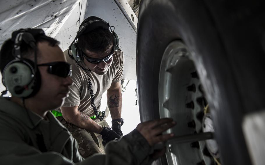 Staff Sgt. Carlos Borges, a crew chief with the 5th Expeditionary Air Mobility Squadron, left, and a fellow airmen tighten a new C-17 Globemaster III tire on the jet during a tire change at an undisclosed location in Southwest Asia on Tuesday, March 21, 2017.