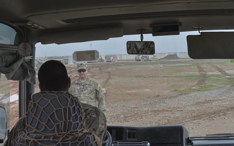 Rain turns the powdery dirt of Qayara Airfield West, Iraq, into a muddy sludge, which bogged down a bus full of reporters on the base, March 17, 2017. Pictured here on that day, Lt. Col. Sebastian Pastor, the base commander, helps instruct a bus driver in how to get out of the mire.