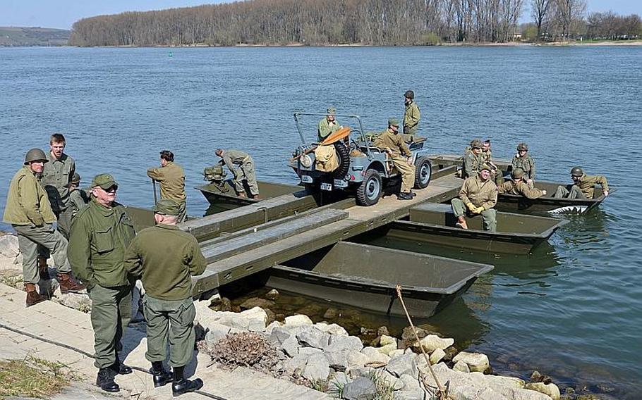 World War II re-enactors crossed the Rhine River in this vintage pontoon raft following the unveiling of the Rhine River crossing monument in Nierstein, Germany, Saturday, March 25, 2017.