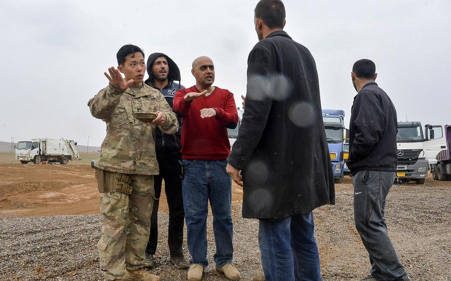 U.S. Army 1st Lt. Adam Ward gives instructions to a group of Iraqi truck drivers, aided translator Emaad Kudear, a contract linguist attached to the 2nd Battalion, 508th Infantry Regiment, at a coalition tactical base south of Mosul, Iraq, March 2, 2017.