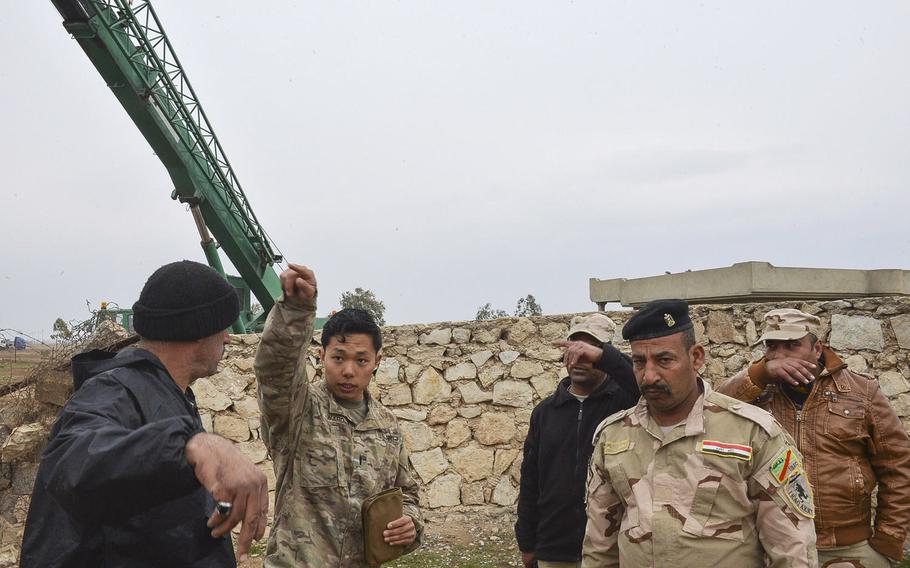 U.S. Army 1st Lt. Adam Ward gives instructions on the positioning of blast walls and other matters during an impromptu meeting with his Iraqi counterparts on a coalition base being built south of Mosul, Iraq, March 2, 2017.