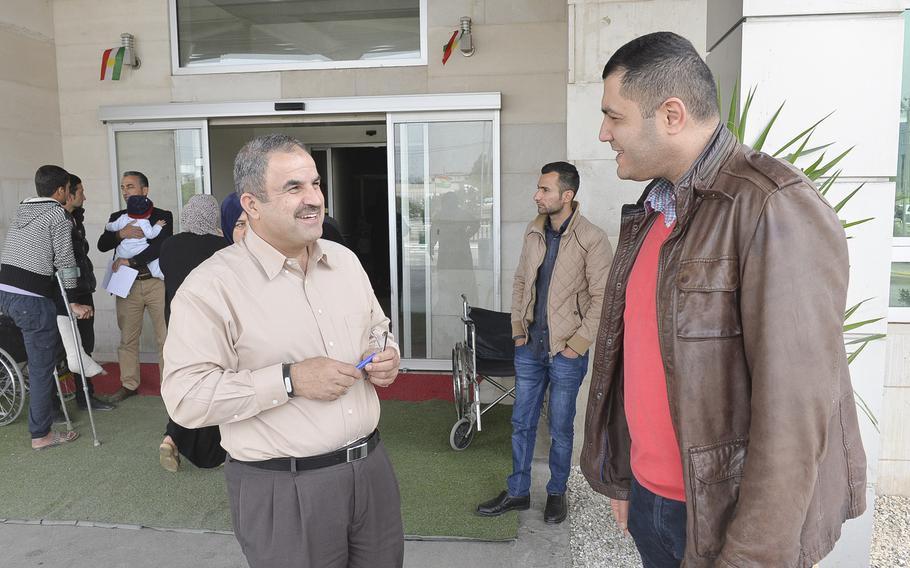 Avdal Wasman, left, a charge nurse at the West Irbil Emergency Hospital in Iraq, chats with Dr. Hazhem Mama, an orthopedic surgeon and administrator at the medical center.