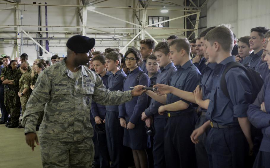 A security forces airman lets Royal Air Force Air Cadets from all over England inspect his baton during a demonstration of U.S. Air Force operations and equipment at RAF Lakenheath, England, Friday, April 7, 2017.