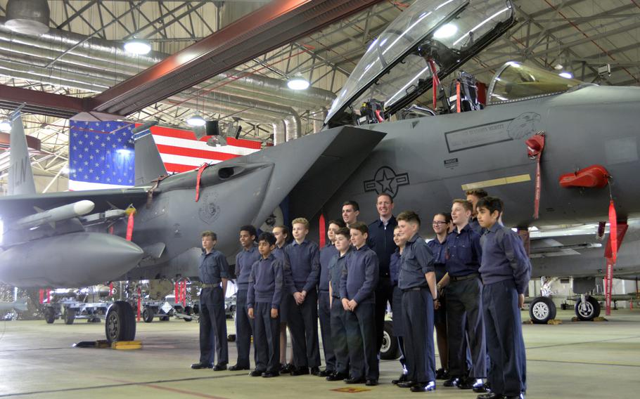 Royal Air Force Air Cadets pose with their instructor for a photograph with an F-15 Eagle fighter jet during a tour of U.S. Air Force operations and equipment at RAF Lakenheath, England, Friday, April 7, 2017.