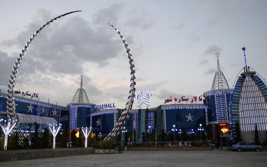 Exterior lights of the City Star Hall in Kabul, Afghanistan, are turned on at dusk, a few hours before a wedding ceremony on Tuesday, April 18, 2017.