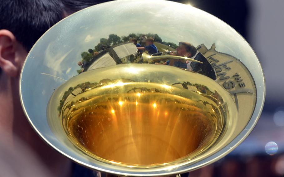 The Bitburg High School band and the school are reflected in a horn at the school's closing ceremony in Bitburg, Germany, Thursday, June 8, 2017.