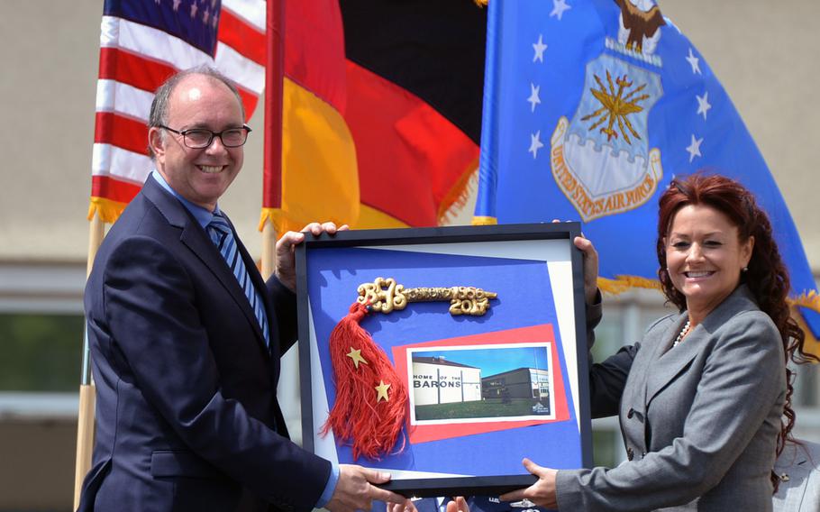 Bitburg High School principal Jennifer Remoy, right, presents Bitburg Deputy Mayor Michael Ringelstein the symbolic key to the school during BHS' closing ceremony, Thursday, June 8, 2017.