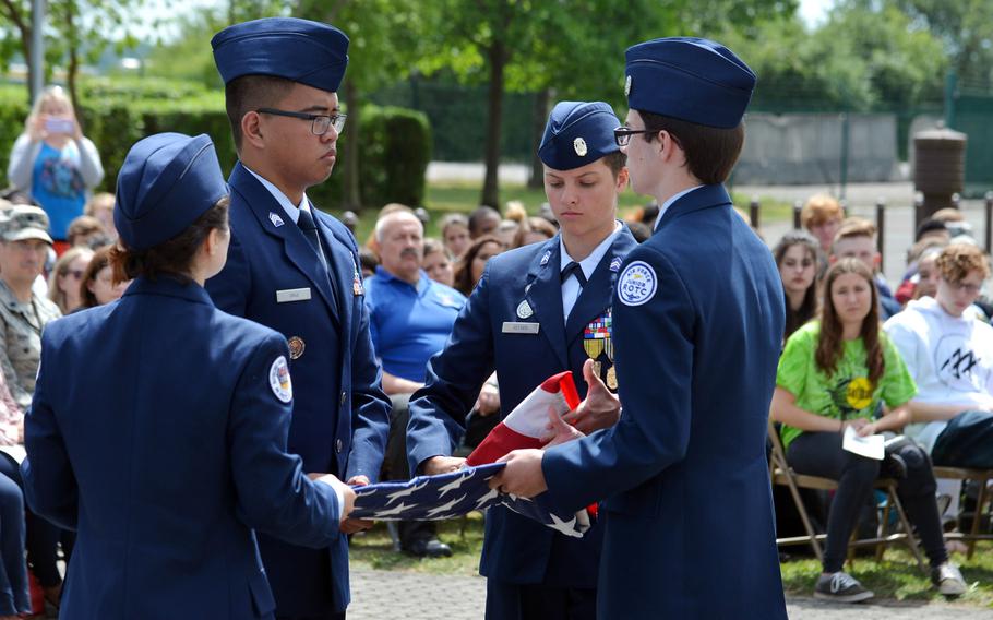 After lowering the American flag for the last time, Bitburg High School JROTC students Madison Tulik, from left, Louis Cruz, Nicole Keyser and Evann Richardson fold the flag before presenting it to principal Jennifer Remoy, Thursday, June 8, 2017.