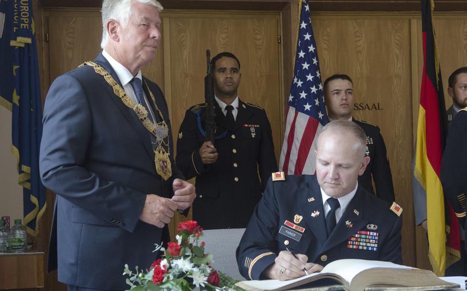 Col. Rob Parker, right, commander of the U.S. Army's 5th Signal Command, signs the golden book of Worms, Germany, in the city hall at a ceremony on Wednesday, June 21, 2017. The 5th Signal Command, soon to deactivate under Department of Defense streamlining efforts, paid a final farewell to the city.