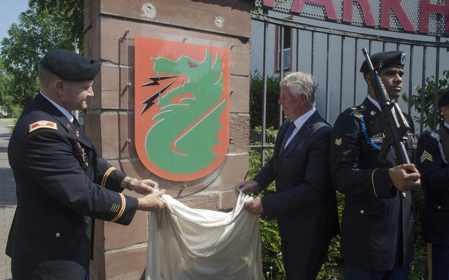 Col. Rob Parker, left, commander of the U.S. Army's 5th Signal Command, and Worms, Germany, Mayor Michael Kissel unveil a crest with the unit's insignia outside the command's former base at Taukkunen Barracks, now a hotel complex, in a ceremony Wednesday, June 21, 2017. 