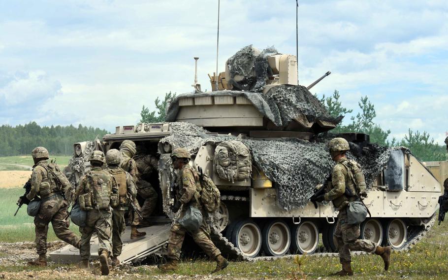 Soldiers with the Army's 1st Battalion, 68th Armored Regiment, pile into the back of a Bradley Fighting Vehicle during a live fire exercise in Grafenwoehr, Germany, Friday, Aug. 4, 2017.