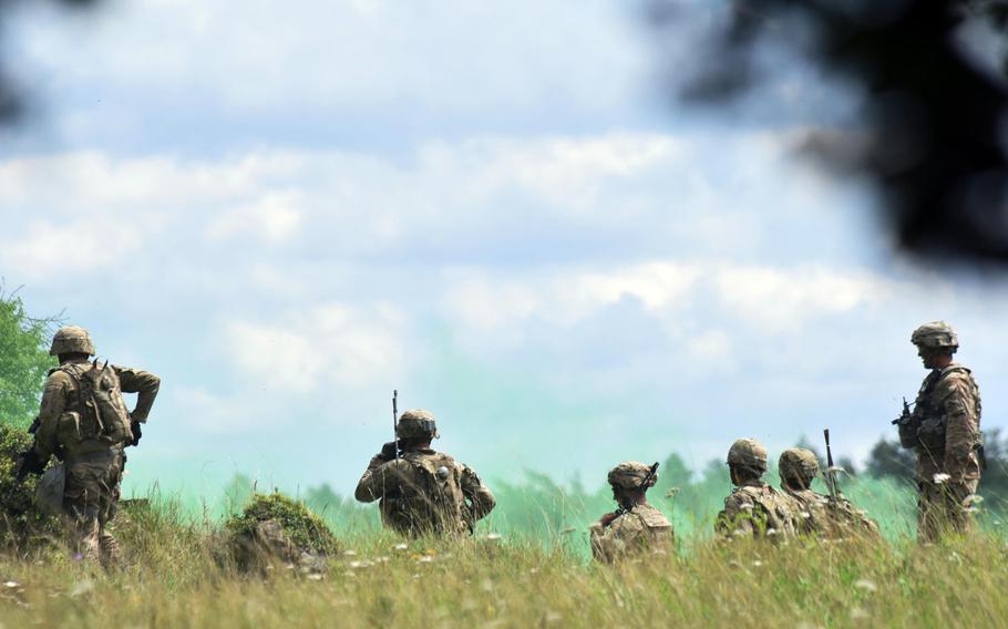 Soldiers with the Army's 1st Battalion, 68th Armored Regiment radio their command after securing an area during a live-fire exercise in Grafenwoehr, Germany, Friday, Aug. 4, 2017.
