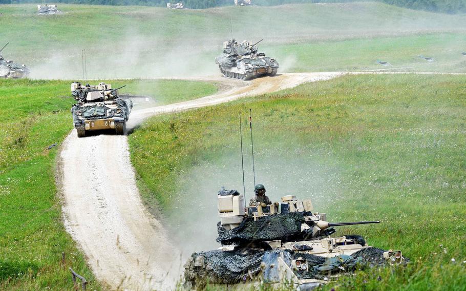 Bradley Fighting Vehicles maneuver to an extraction point to bring their dismounted soldiers away from the front lines during a live-fire exercise in Grafenwoehr, Germany, Friday, Aug. 4, 2017.