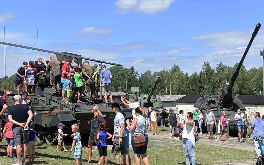 American and German families climb on top of military vehicles from both nations at the 59th annual German-American Volksfest in Grafenwoehr, Germany, on Saturday, Aug. 5, 2017.