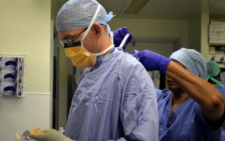 Maj. Richard Knight, urologist with the 48th Medical Group based at RAF Lakenheath, dons surgical gear before  robotic-assisted surgery at the Norfolk and Norwich University Hospital in Norwich, England, Monday, July 31, 2017. Military doctors like Knight have been working at British hospitals under an agreement with the 48th MDG.