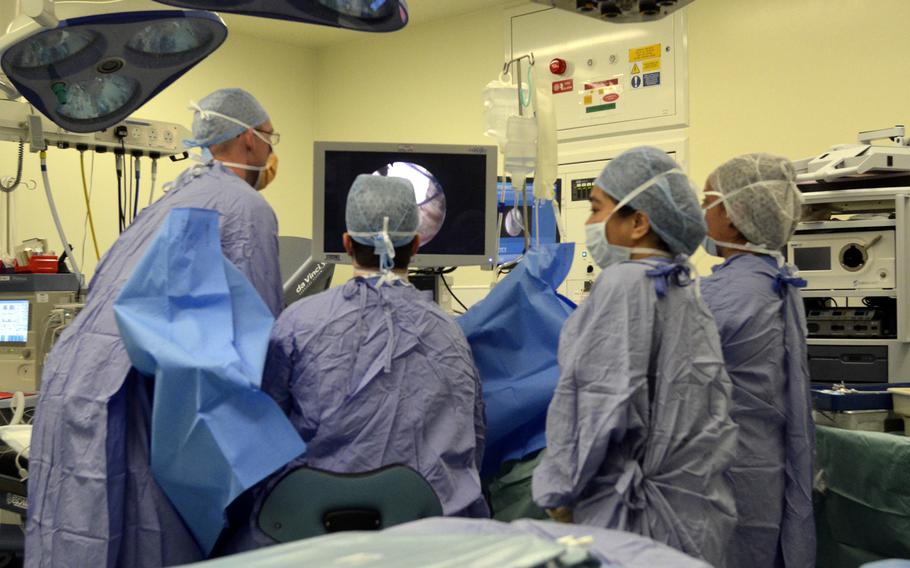 Maj. Richard Knight, left, urologist with the 48th Medical Group based at RAF Lakenheath, works with a surgical team during an operation at the Norfolk and Norwich University Hospital in Norwich, England, Monday, July 31, 2017.