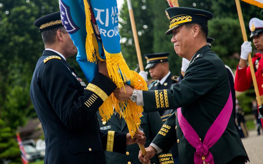 Gen. Leem Ho-young, outgoing deputy commander of Combined Forces Command, passes the guidon to Gen. Vincent Brooks during a ceremony at Yongsan Garrison, South Korea, Friday, Aug. 11, 2017.