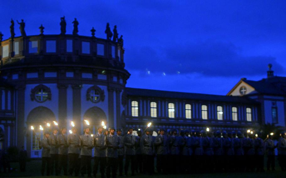 Bundeswehr soldiers stand during the playing of the Grosser Zapfenstreich, or Grand Tattoo, Thursday, Aug. 10, 2017 at Biebrich Palace in Wiesbaden, Germany. The palace, built in the early 18th century, has been the site of the past three tattoos — solemn evening military band performances — bidding farewell to leaders of U.S. Army Europe.