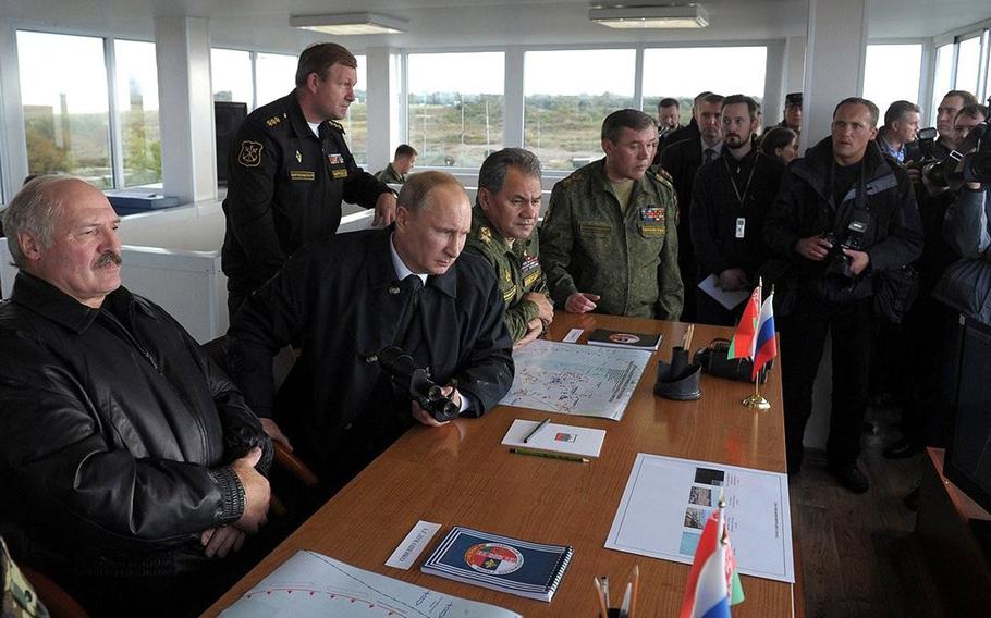 Belarus President Alexander Lukashenko, left, and Russia President Vladimir Putin watch the final stage of the Zapad military exercises at the Khmelyovka test ground, Russia, in Sept. 2013.