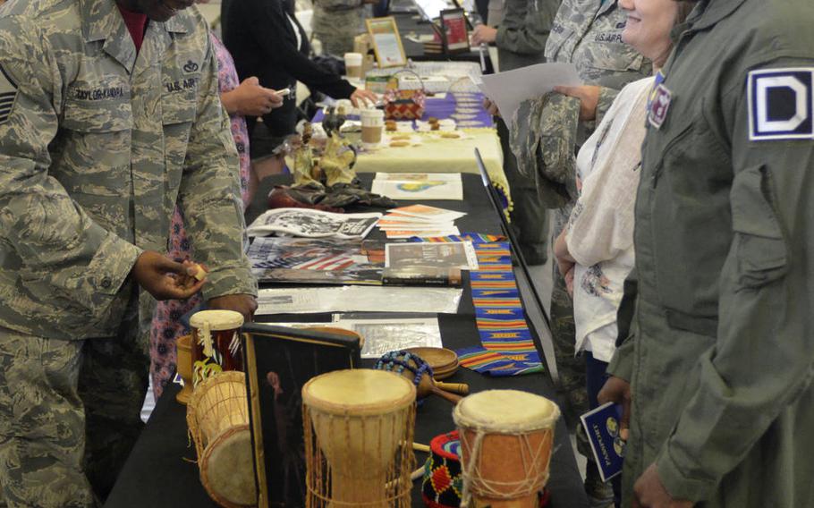 Servicemembers and family members examine musical instruments in England at RAF Mildenhall's Diversity and Inclusion Day on Aug. 18, 2017.