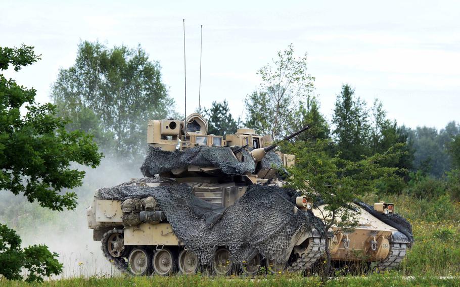 A Bradley Fighting Vehicle drives towards the a line of M1A2 Abrams tanks during a live fire exercise, Aug. 18, 2017, in Grafenwoehr, Germany.