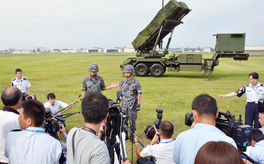 Japan Air Self-Defense Force personnel talk to reporters in front of a Patriot missile-defense system at Yokota Air Base, Japan, Tuesday, Aug. 29, 2017.