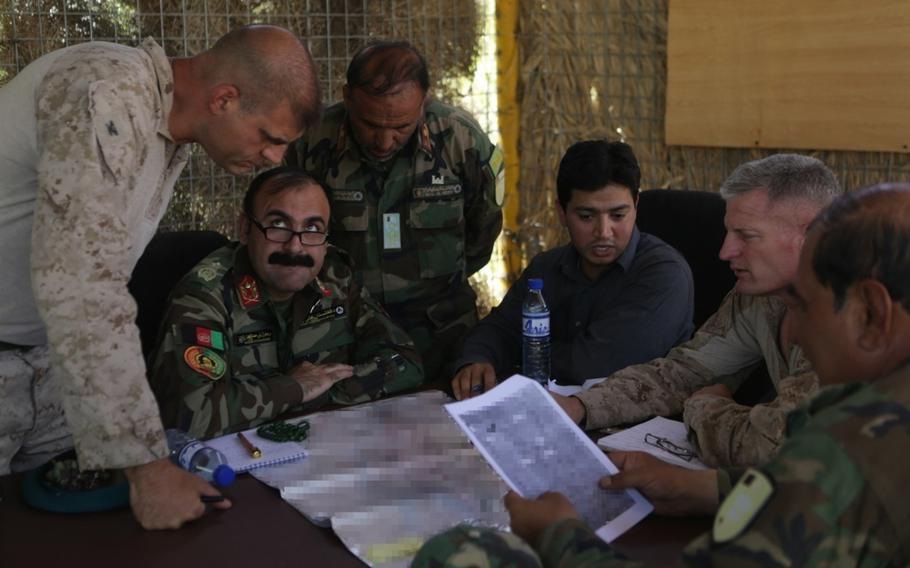 U.S. Marine Col. Mathew Grosz, senior advisor to the Afghan National Army 215th Corps, Maj. Gen. Wali Mohammed Ahmadzai, commander of 215th Corps, U.S. Marine Brig. Gen. Roger Turner, commanding general of Task Force Southwest, and other Afghan soldiers discuss plans for Operation Maiwand Five near Nawa district in Helmand Province, on Aug. 21, 2017. The operation is aimed at clearing insurgents from areas near the provincial capital.