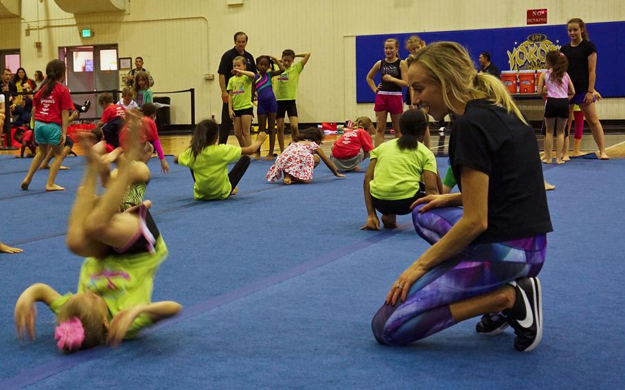 Nastia Liukin, all-around women's gymnastics champion and three-time silver medalist at the 2008 Summer Olympics, watches a child's successful forward roll during a youth gymnastics clinic at Yokota Air Base, Japan, Thursday, Aug. 30, 2017.