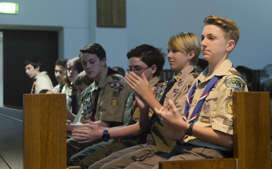 Members of Wiesbaden's Boy Scout Troop 107 applaud their fellow Scouts as they are awarded merit badges at a meeting in Wiesbaden, Monday, Sept. 18, 2017, that commemorated the troop's 60th anniversary.