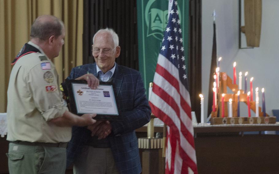 Jeff Stone, former scoutmaster of Wiesbaden Boy Scout Troop 107, passes a certificate of appreciation to Dietrich Kroger, a resident of the village of Breckenheim, near Wiesbaden, during a ceremony at Hainerberg chapel, Monday, Sept. 18, 2017. 