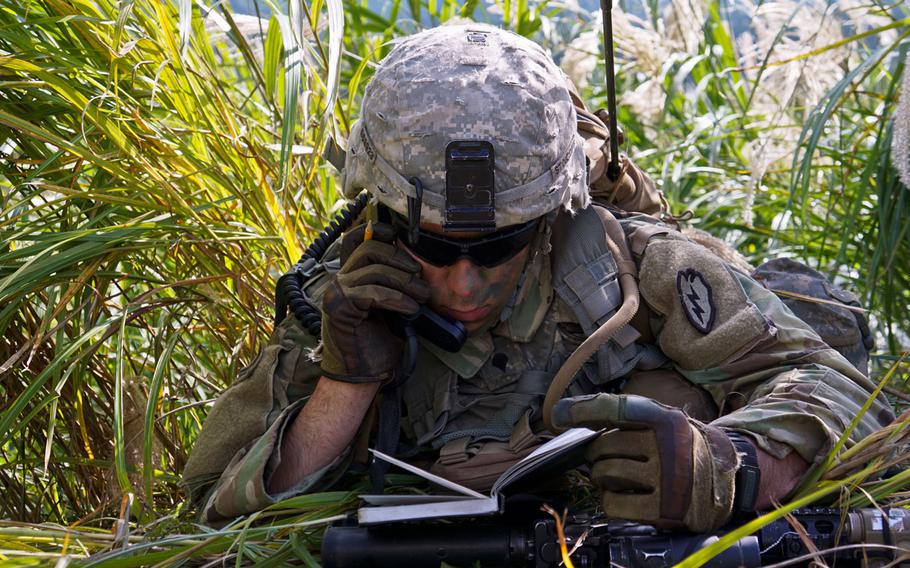 Spc. Elijah Stoicoff, an artillery forward observer assigned to C Company, 3rd Battalion, 21st Infantry Regiment, listens to the radio while conducting live-fire training during the Orient Shield exercise at East Fuji Maneuver Area, Japan, Tuesday, Sept. 19, 2017.