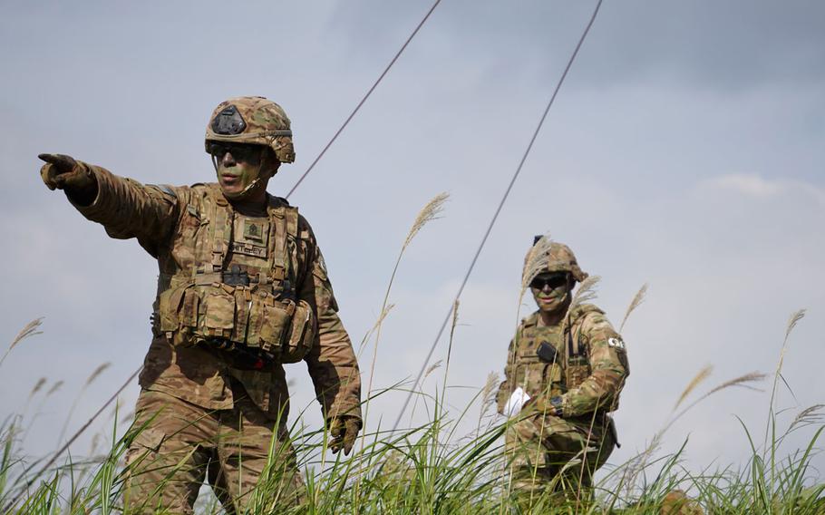 Sgt. Maj. Robert Whiteley of the 3rd Battalion, 21st Infantry Regiment "Gimlets," directs soldiers as they cross a road while conducting live-fire training during Orient Shield drills at East Fuji Maneuver Area, Japan, Tuesday, Sept. 19, 2017.