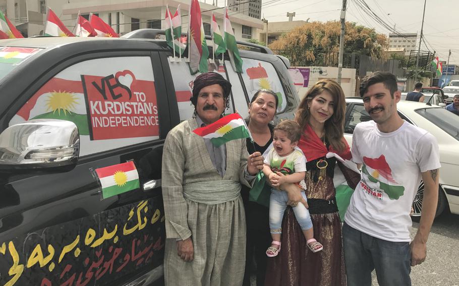 Sami Abbas Kakai, left, stands with his family, including son Mardin Kakai on the far right, after they cast ballots in the Kurdistan region's independence referendum at a polling place in Ankawa, a suburb of the region's capital of Irbil, on Monday, Sept. 25, 2017.