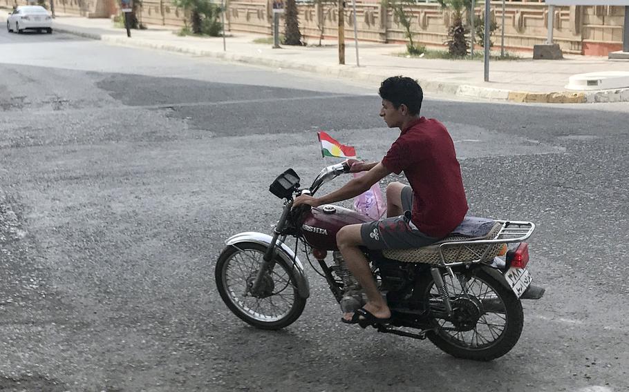 A motorcyclist drives through the streets of Ankawa, a suburb of the Kurdistan region's capital of Irbil, flying a Kurdish flag on Monday, Sept. 25, 2017. Many vehicles, buildings and other structures were bedecked with Kurdish flags to promote the region's independence referendum.