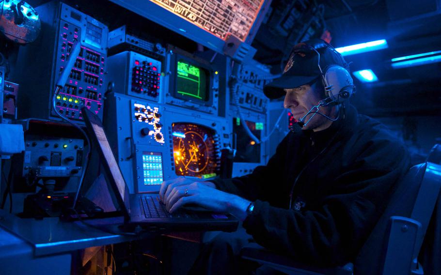 A sailor stands watch in the combat information center aboard the guided-missile destroyer USS John S. McCain as it sails east of the Korean Peninsula in 2014.