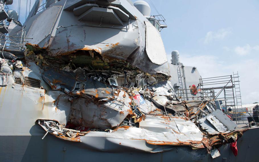 The guided-missile destroyer USS Fitzgerald sits in dry dock over the summer at Yokosuka Naval Base, Japan, to continue repairs and assess damage sustained from its June 17 collision with a merchant vessel. This view shows damage above the waterline to the outside skin of the ship.