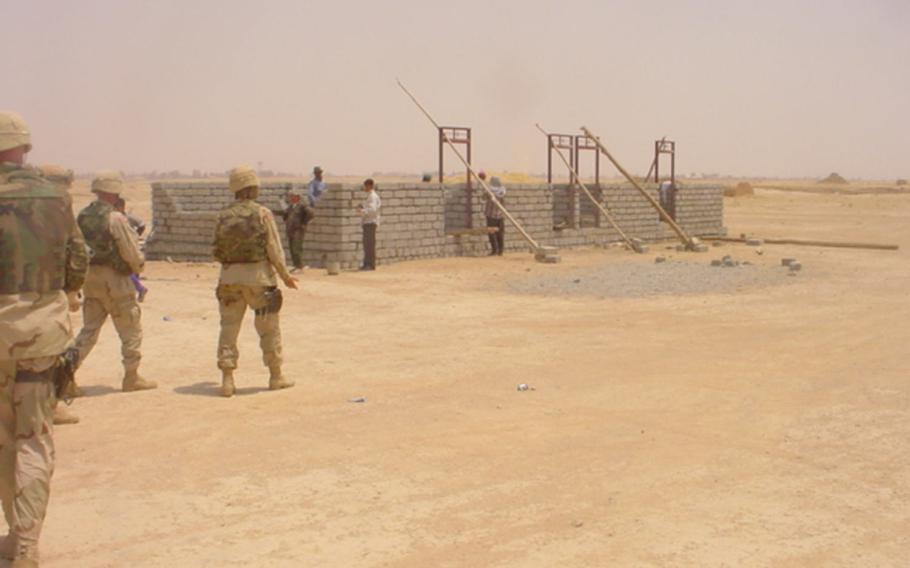 American soldiers are pictured visiting a school under construction in the village of Jeddalah, near Qayara Airfield West, in this photo dated Monday, July 7, 2003.