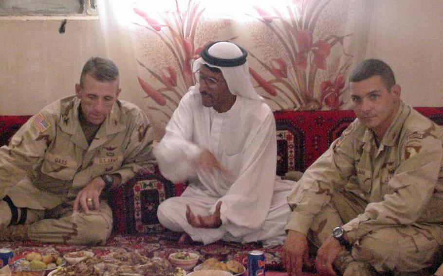 Pictured here sharing a meal in Jeddalah sometime in 2003 are, left to right, Col. Gregory Gass, Dr. Mohammed Ismail and Maj. Fred Wellman. Wellman said meals like this defined the Iraq War experience more than ''kicking down doors.''