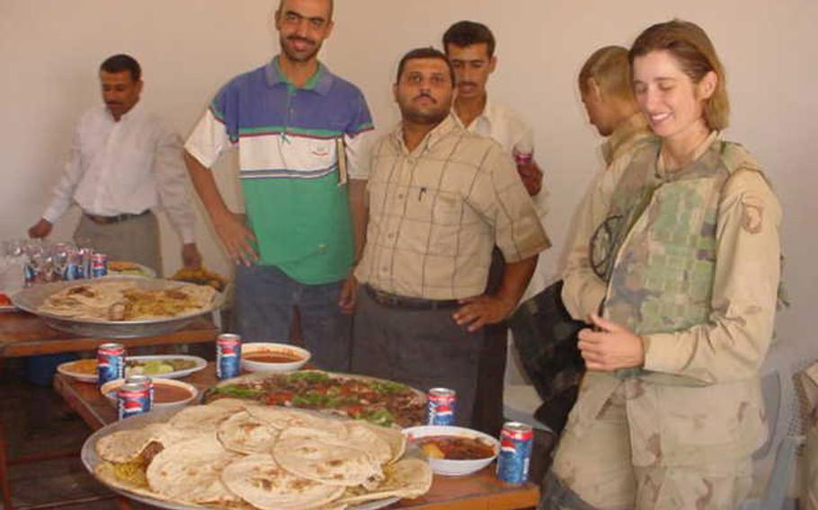 Pictured at a lunch in this undated photo from Fred Wellman's collection are Iraqi translators Bassam Sabry, left in green and blue, and Osama Saado to his right with then-Capt. Kellie Rourke on the far right.