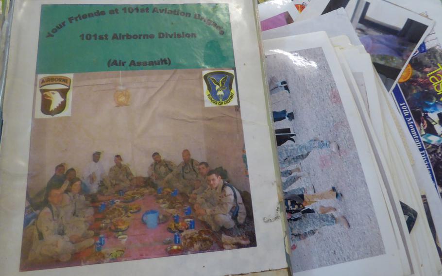 A photo album the 101st Airborne Division's combat aviation brigade gave to the people of Jeddalah and dozens of loose photos and other cherished mementos were stacked on a table in the village sheikh's house during a visit on Friday, Sept. 8, 2017.