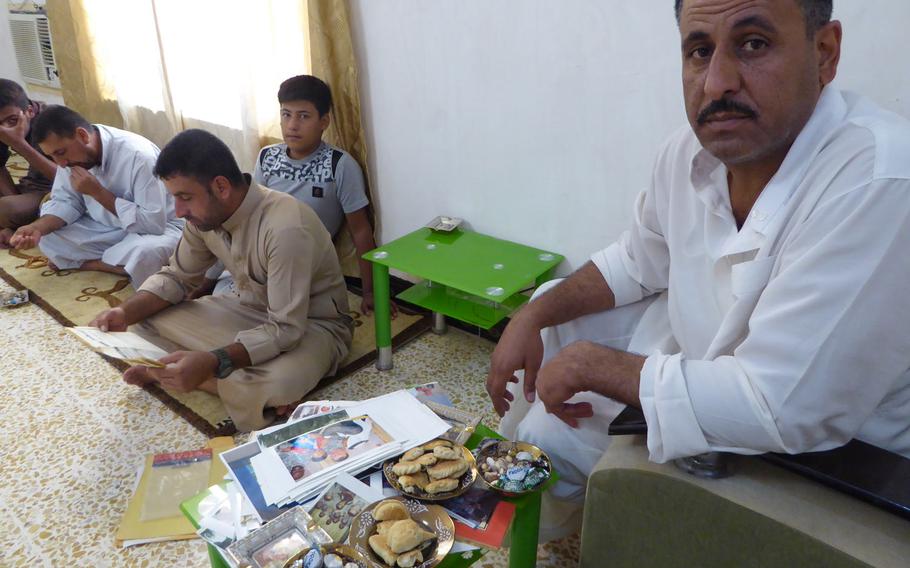 Pictured here at their home in Jeddalah on Friday, Sept. 8, 2017, Hussein Ismail, right, and other family members sort through mementos of their years working with U.S. troops who built schools, clinics and roads in their village and others around Qayara Airfield West, a logistics hub in northern Iraq about 40 miles south of Mosul.
