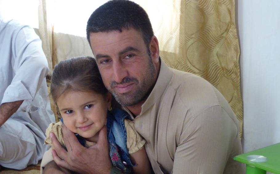 Hachim Ismail, 33, poses with his 4-year-old daughter Remas in his brother's home in Jeddalah, near Qayara Airfield West. Ismail's older brother was sheikh of the village in 2003 and was a key partner for U.S. reconstruction efforts in the area before he was killed in 2011.
