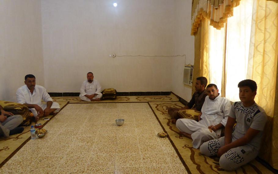 Hussein Ismail, left, gathers with family members in the front room of his house in the village of Jeddalah. Ismail, the village sheikh, worked with American troops during Iraq's early reconstruction in 2003. His brother, Dr. Mohammed Ismail, the previous sheikh, was killed by insurgents here in 2011.