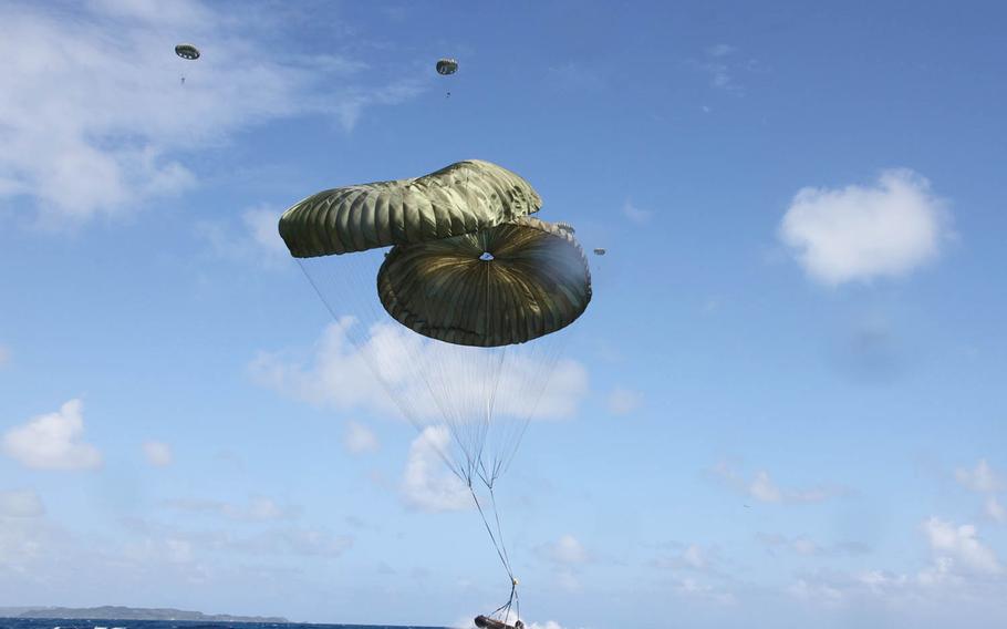 A Combat Rubber Raiding Craft falls onto the sea off Okinawa's eastern coast as Marines from 3rd Reconnaissance Battalion, 3rd Marine Division, descend in the background, Wednesday, Oct. 11, 2017.
