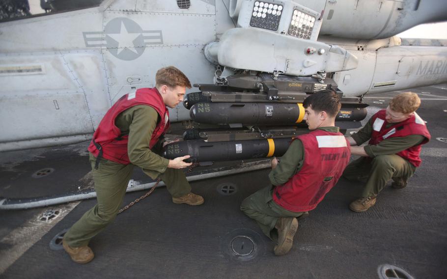 Marines with the 22nd Marine Expeditionary Unit attach AGM-114 Hellfire missiles onto an AH-1W Super Cobra aboard the amphibious transport dock ship USS San Antonio in support of Libya against the Islamic State, Nov. 8, 2016.