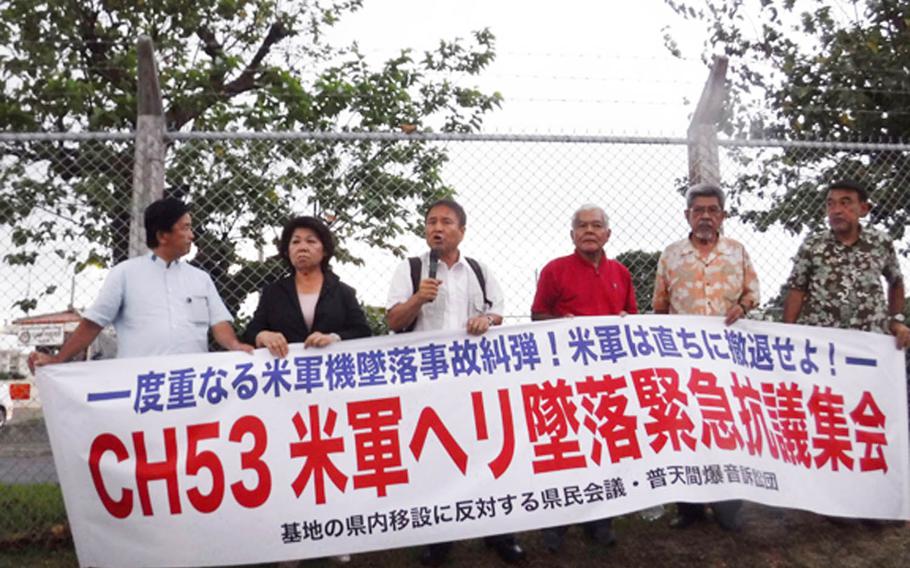Okinawan protest leader Hiroji Yamashiro of the Okinawa Peace Activity Center, third from left, speaks during a rally outside Camp Foster, Okinawa, Thursday, Oct. 12, 2017. About 200 people turned out to protest the recent inflight fire and emergency landing of a Marine Corps CH-53E Super Stallion on farmland outside the Northern Training Area.