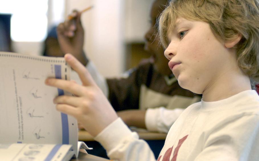 A fifth-grader at Landstuhl Elementary and Middle School, Germany, looks through his TerraNova test. Scoring discrepancies in the spring standardized assessment have delayed the release of results for some 33,000 DODEA students.