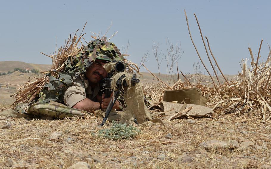 A Kurdish sniper sights in on a target during an exercise at a training site outside Irbil, the capital of Iraq's Kurdish region, on July 26, 2016. The exercise was the culmination of a training program to prepare peshmerga fighters for combined arms operations with snipers and artillery supporting infantry troops.
