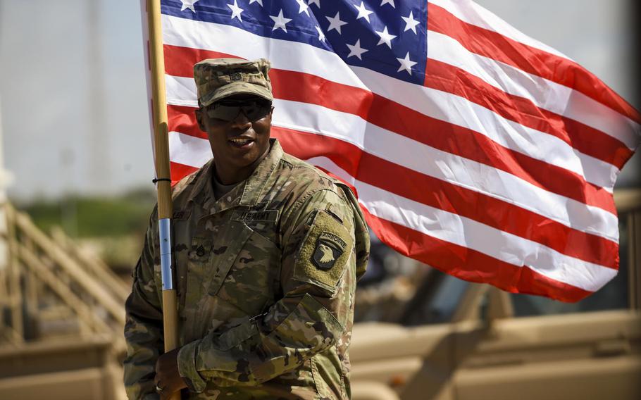 Army Staff Sgt. Anthony Miller with the 101st Airborne Division holds the American flag during a graduation ceremony for Somali National Army soldiers in Mogadishu, Somalia, May 24, 2017.