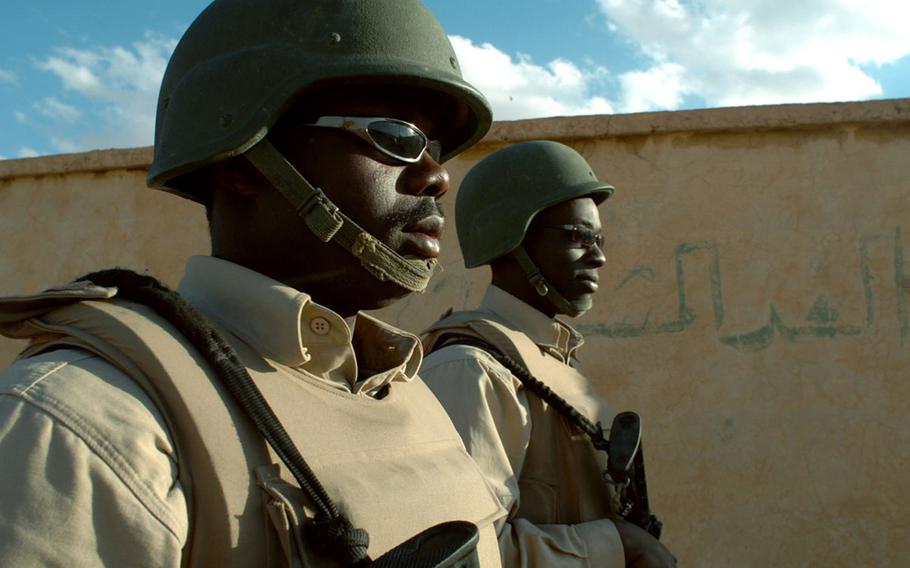 Matia Tibenda, and Alvin Ochieng, Ugandan contractors, do a roving patrol during a guard shift at Al Asad Air Base, Iraq, in 2006. Contractor Triple Canopy has agreed to pay a $2.6 million settlement to resolve claims that they billed the military for unqualified security guards at Al Asad Air Base in Iraq.